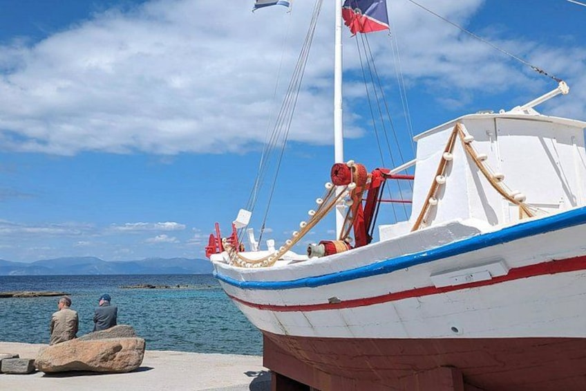 A boat docked at a pier with a clear sky and calm sea in the background. 4