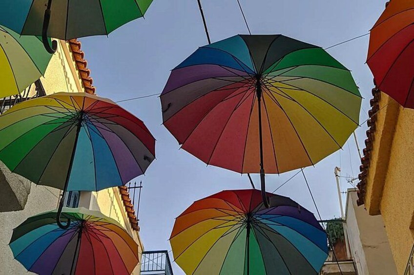 A street with colorful umbrellas hanging overhead. 5