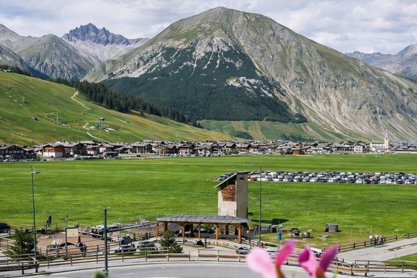 A mountain village with a parking lot, buildings, and a prominent mountain in the background. 5