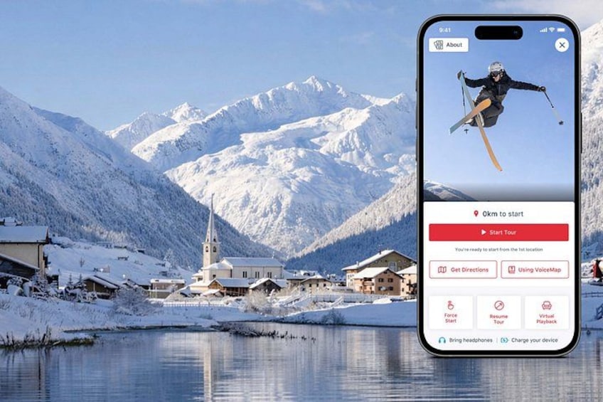 Un teléfono inteligente mostrando una aplicación para excursiones de esquí con un paisaje montañoso nevado al fondo. 1