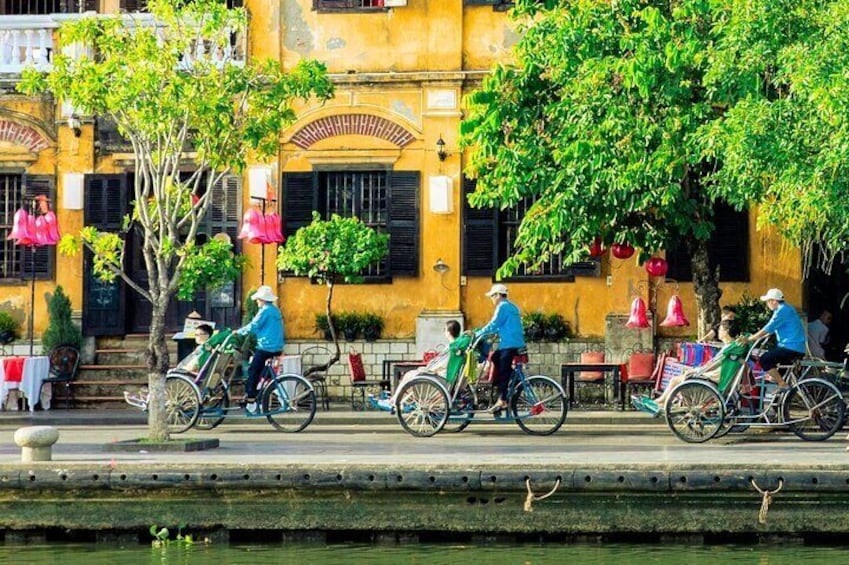 A canal with people riding bicycles along the path. 3