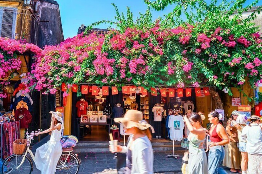 A bustling street market with people shopping and a bicycle parked in front of a shop. 2