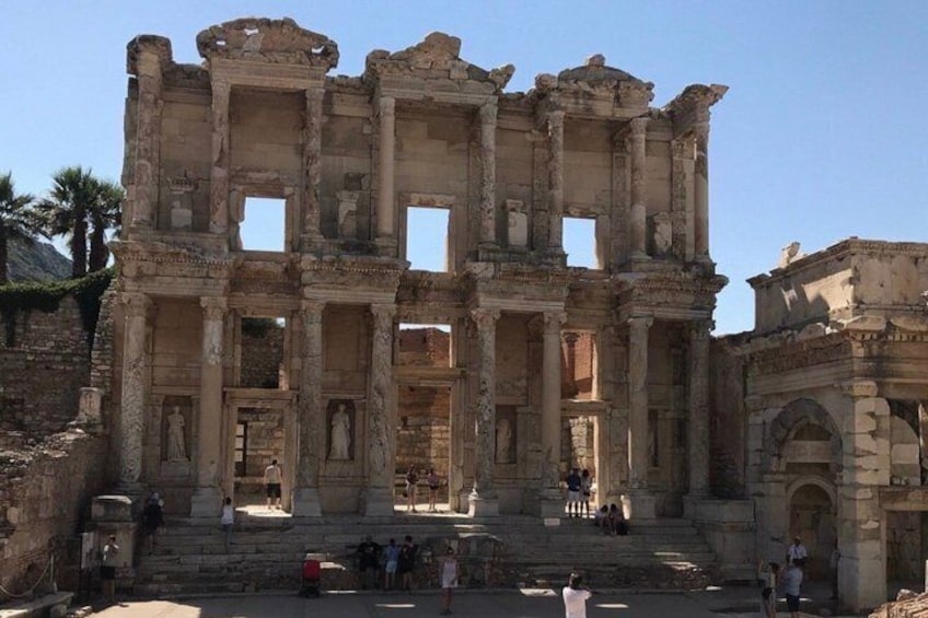 The ruins of an ancient structure with columns and arches, surrounded by visitors. 5