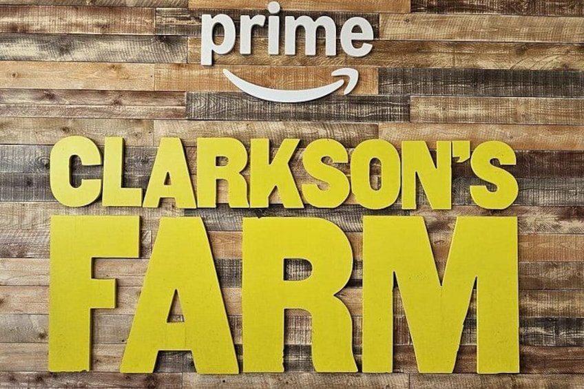 Un fondo de madera con el texto 'CLARKSON'S FARM' y un logotipo de Prime. 1