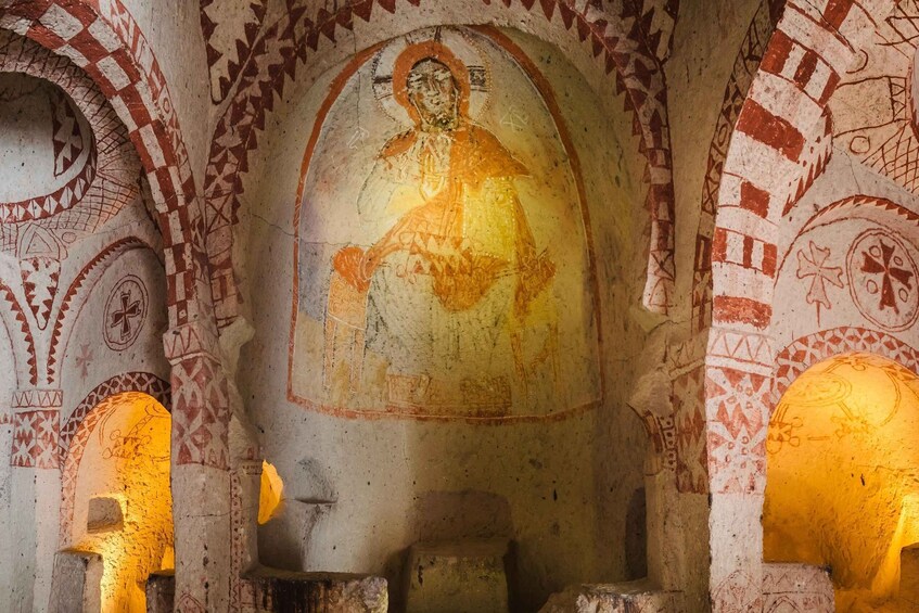 A mosaic of a religious figure in a church with geometric patterns and arches. 2
