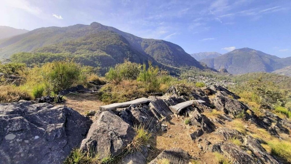 A rocky mountain landscape with a wooden bench and sparse vegetation. 5