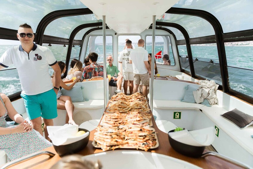 A boat with people dining and a long table of food. 3