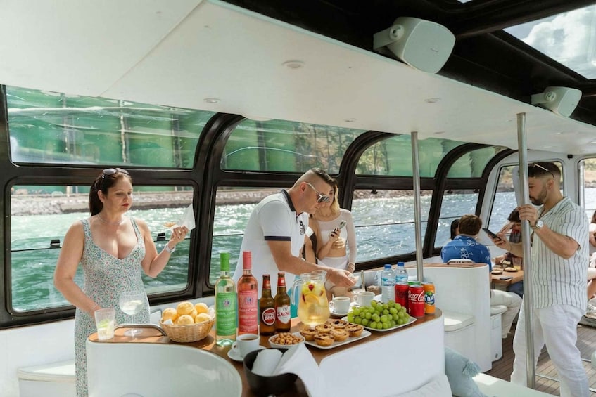 A boat with people dining and a table with food and drinks. 1