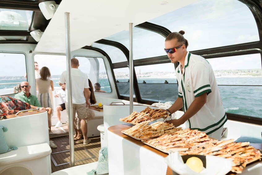 A person serving food on a boat with passengers in the background. 5