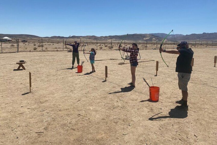 An outdoor archery range with targets and participants. 3