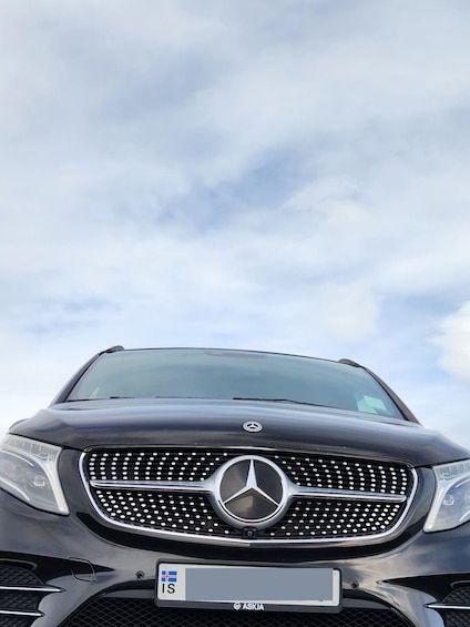 A Mercedes-Benz SUV with a visible license plate and a clear sky in the background. 3