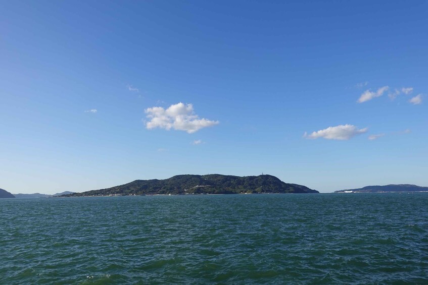 A calm sea with a small island in the distance under a clear blue sky. 4