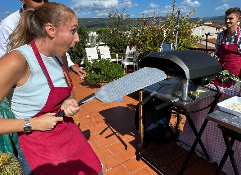 A person grilling outdoors with a barbecue grill and a spatula. 5
