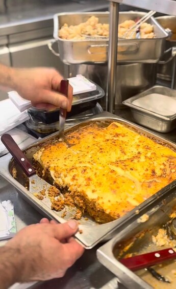 A person serving a baked dish from a tray. 3
