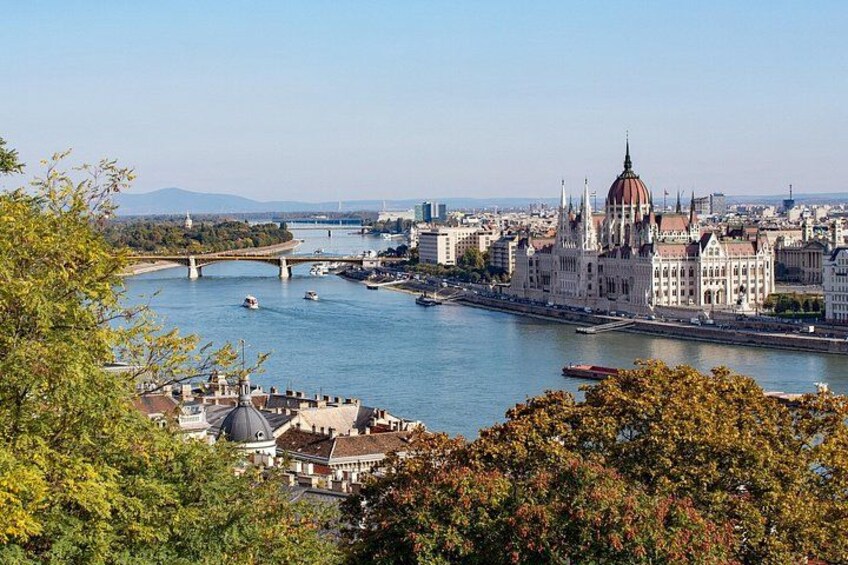 A river with boats, a bridge, and a large building with a dome. 1