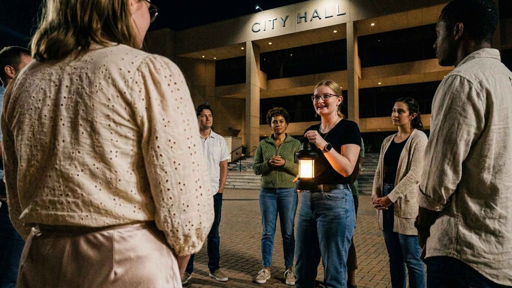 A group of people standing outside a building with a sign that reads 'CITY HALL'. 4