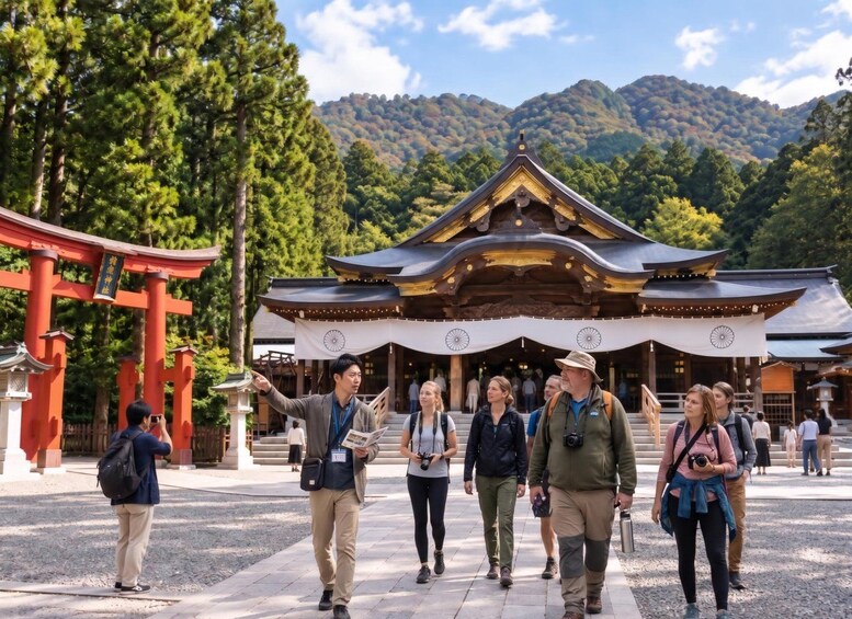 A group of tourists walking towards a traditional Japanese temple with a red torii gate in the foreground. 2