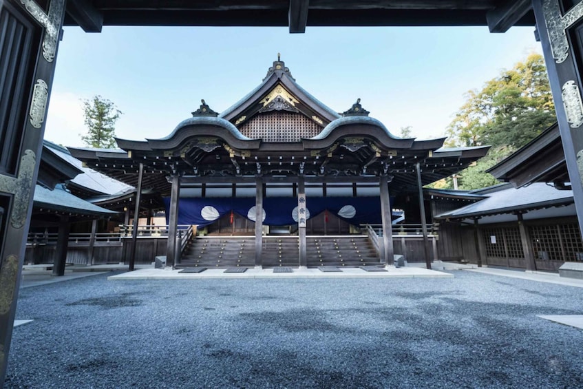 A traditional Japanese temple with a prominent entrance, a staircase leading up to the main hall, and a gravel courtyard. 2