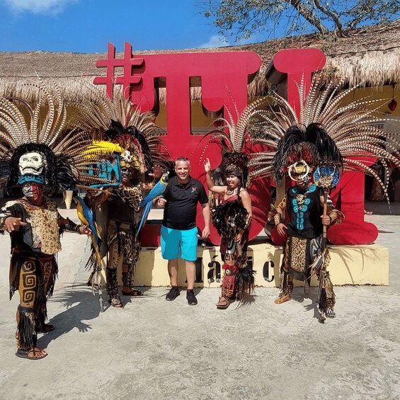 A group of people in traditional costumes standing in front of a large red sign. 3