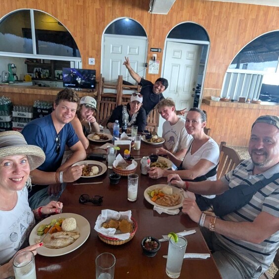 A group of people dining at a restaurant with wooden walls and arched doorways. 4