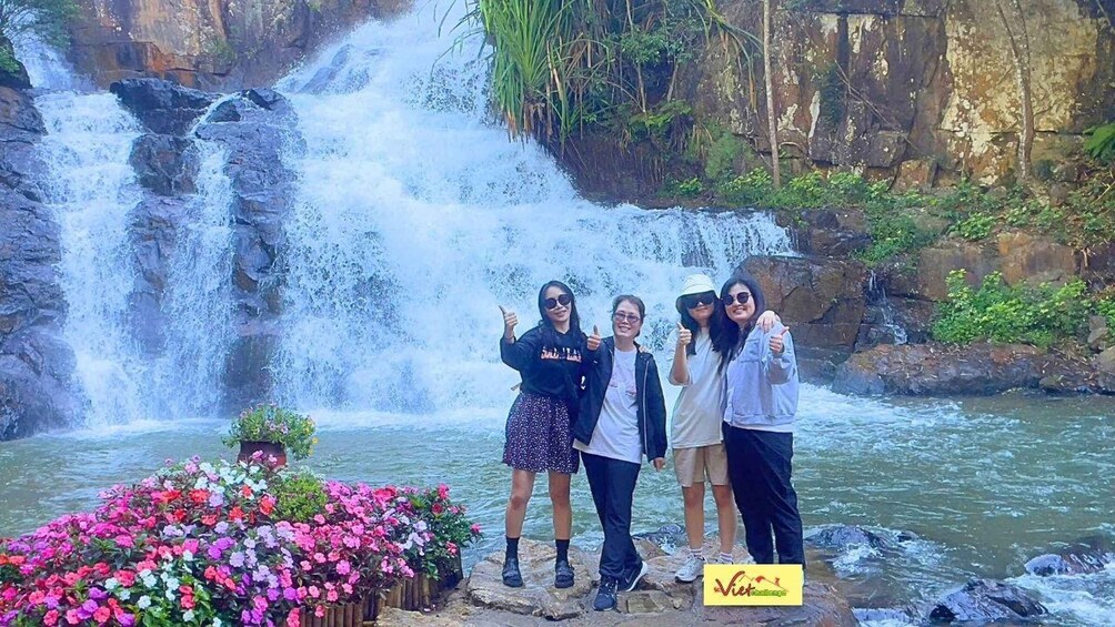 Una cascada con un grupo de personas posando frente a ella. 4