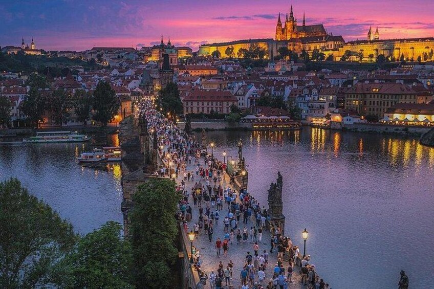 A river with a bridge, a crowd of people, and a historic building in the background. 2