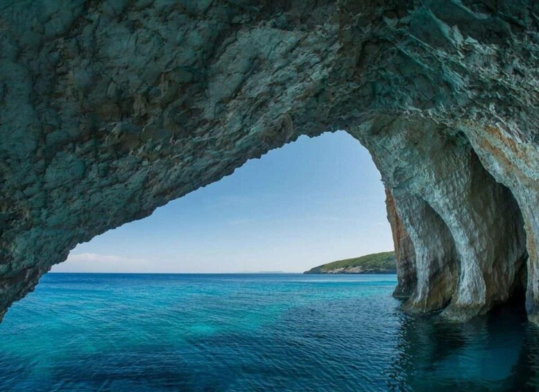 A natural rock formation with a large arch over a body of water. 3