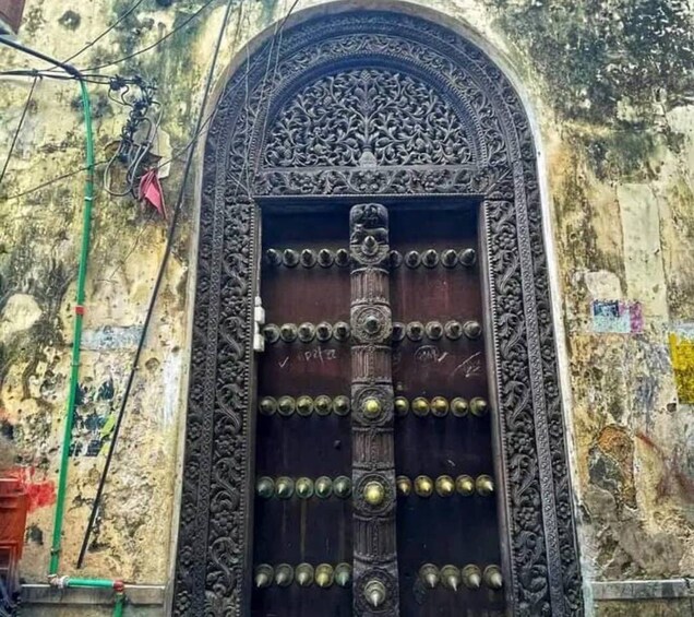 An ornate metal door with intricate carvings and brass fixtures. 1
