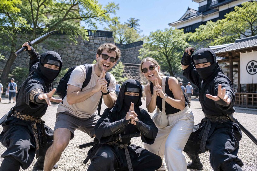 A group of people in ninja attire posing in front of a traditional Japanese building. 3