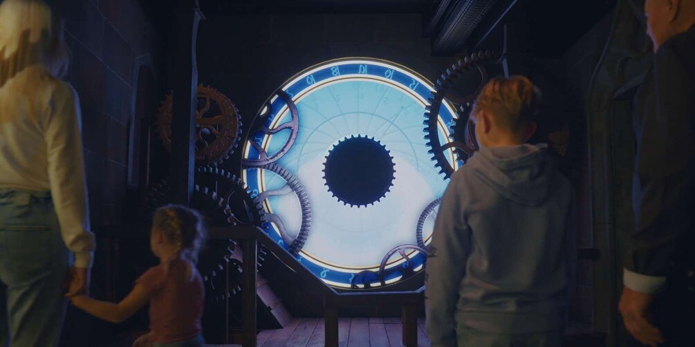 A large mechanical clock with gears and hands, surrounded by people observing it. 4