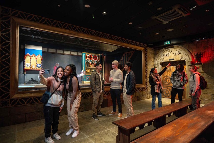 A group of people taking a selfie in a museum with medieval-themed exhibits. 3