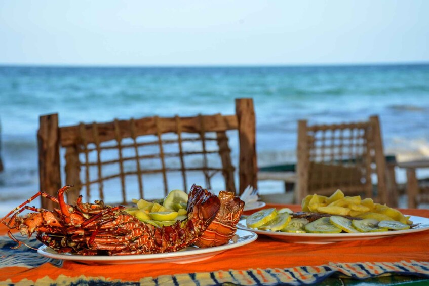 A lobster on a plate with lemon slices, set on a table by the ocean. 2