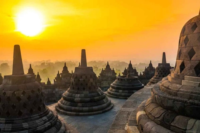 A row of ancient stone stupas under a bright sun. 1