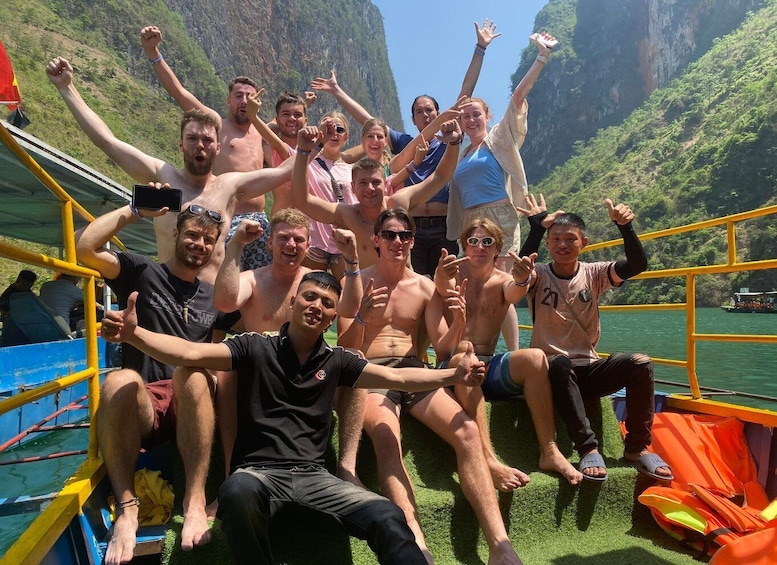 A group of people on a boat with a mountainous landscape in the background. 4