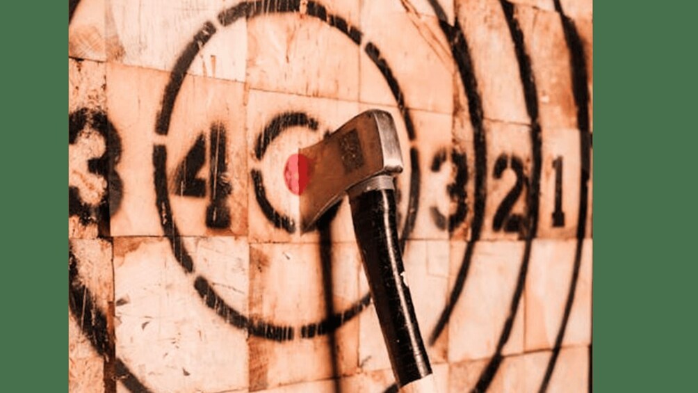 A hammer with a red head against a wall with circular markings. 2