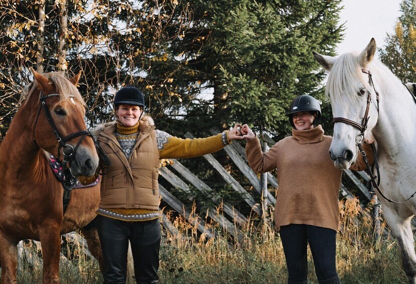 Two people with horses in a natural setting. 2