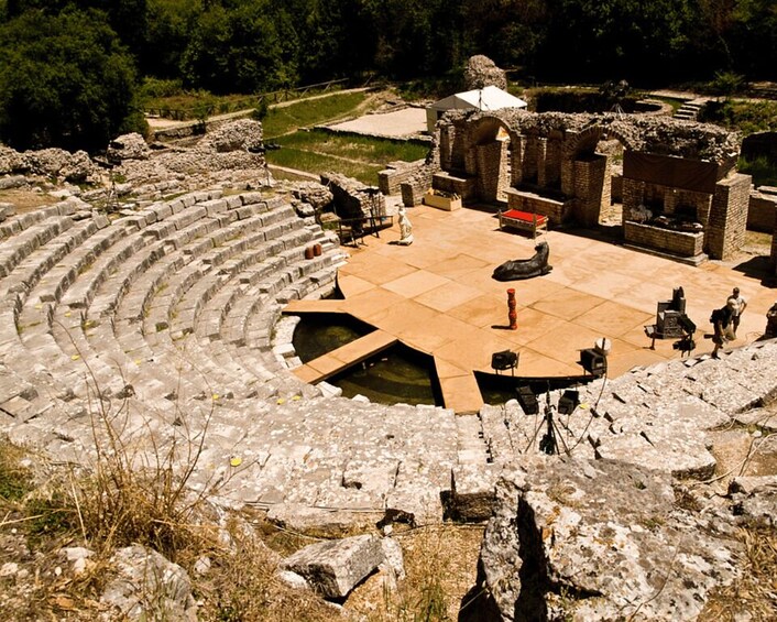 An ancient amphitheater with stone seating and a central stage. 4