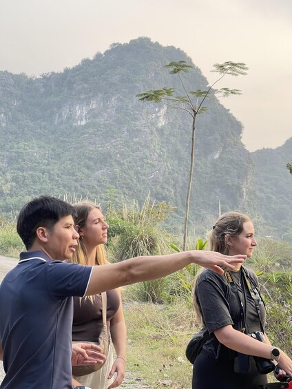 A group of people standing outdoors with a mountainous landscape in the background. 2