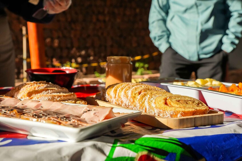 A table with various food items including sliced bread, a loaf of bread, and a jar of sauce. 5