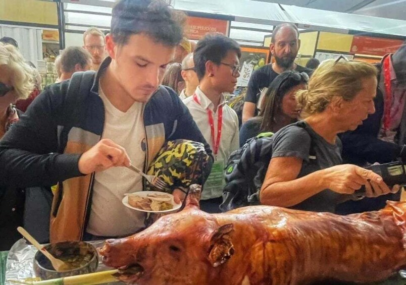 A large roasted pig being served at a busy outdoor event. 2