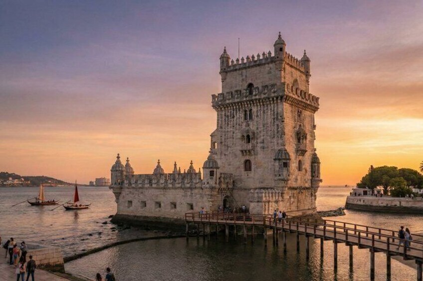 A historic tower by a waterfront with a sunset in the background. 1