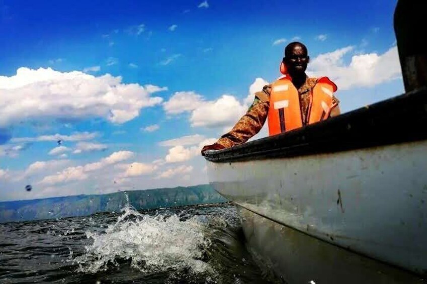 A person in an orange life jacket on a boat. 5