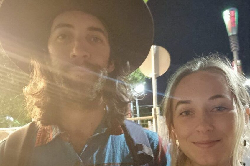 Two people outdoors at night with streetlights in the background. 2