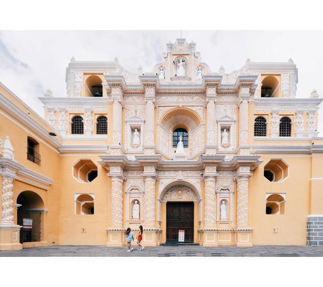 A historic building with ornate architecture, featuring multiple arches and statues. 1