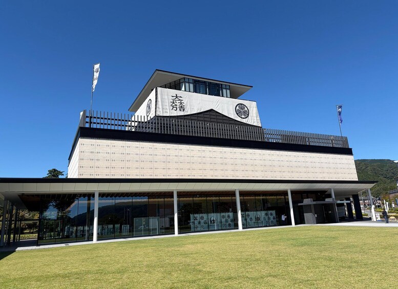 A modern building with a large sign, a flag, and a clear blue sky. 5