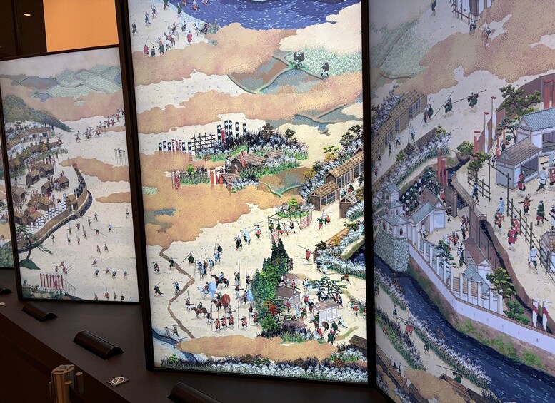 A panoramic view of a historical town with buildings, a river, and people. 3