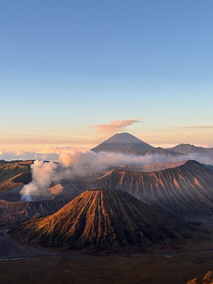 A mountain range with a prominent peak, surrounded by clouds and valleys. 1