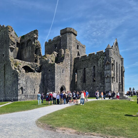 A historic castle with ruins and a grassy foreground. 4
