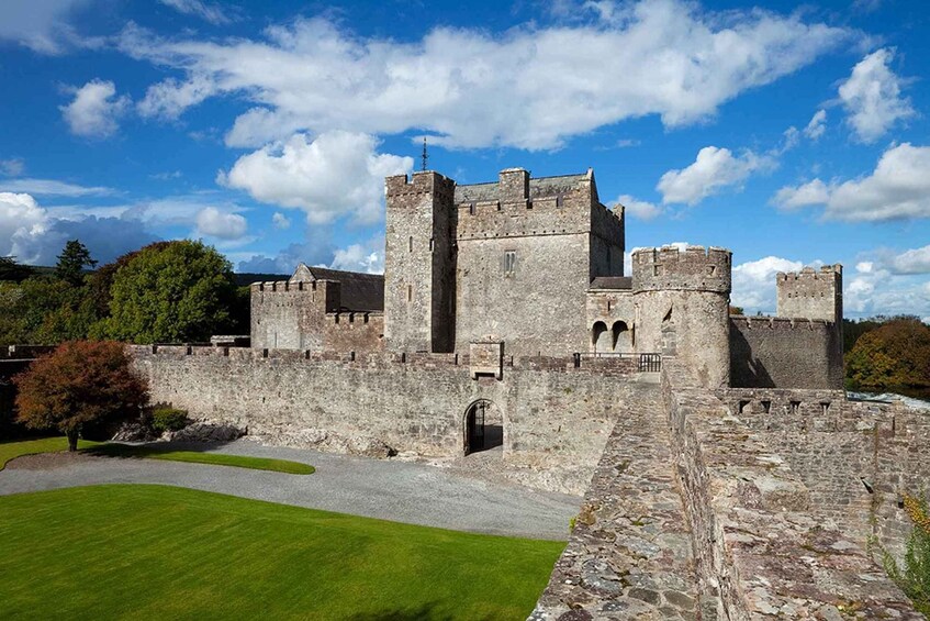 A historic castle with multiple towers and a well-maintained lawn in front. 3