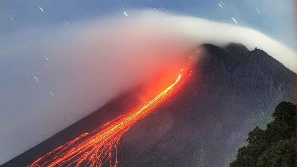 A volcano with lava flowing down its side. 3